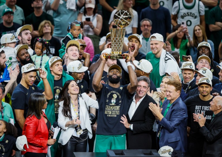 Il giocatore dei Boston Celtics detiene il trofeo del campionato NBA.