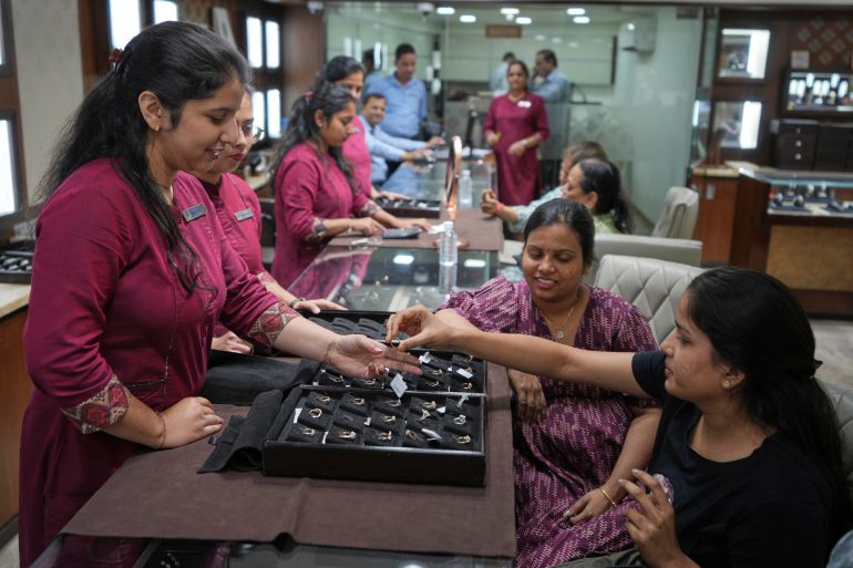 Un venditore mostra un anello di diamanti a un potenziale acquirente in un negozio di gioielli ad Ahmedabad, in India, il 14 aprile 2025 (AP Foto/Ajit Solanki)