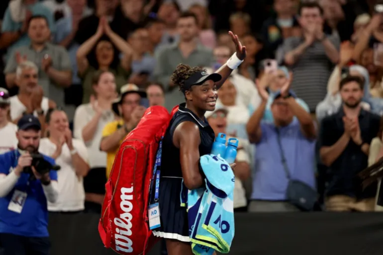 La statunitense Venus Williams riconosce gli applausi mentre esce dal campo dopo aver perso contro la serba Olga Danilovic nel singolare femminile del primo giorno degli Australian Open di Melbourne il 18 gennaio 2026. (Foto di Martin KEEP / AFP) / -- IMMAGINE RISERVATA ALL'USO EDITORIALE - STRETTAMENTE NON PER USO COMMERCIALE --