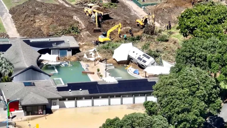Una vista dei droni degli scavatori che lavorano in un campeggio danneggiato da una frana causata da forti piogge, sul Monte Maunganui, Nuova Zelanda, 23 gennaio 2026. TVNZ via REUTERS TV/Handout via REUTERS QUESTA IMMAGINE È STATA FORNITA DA TERZE PARTI. NUOVA ZELANDA FUORI. NESSUNA VENDITA COMMERCIALE O EDITORIALE IN NUOVA ZELANDA. AUSTRALIA FUORI. NESSUNA VENDITA COMMERCIALE O EDITORIALE IN AUSTRALIA. Non utilizzare siti Internet neozelandesi/qualsiasi sito Internet di organizzazioni mediatiche o piattaforme mobili con sede in Nuova Zelanda o Australia.