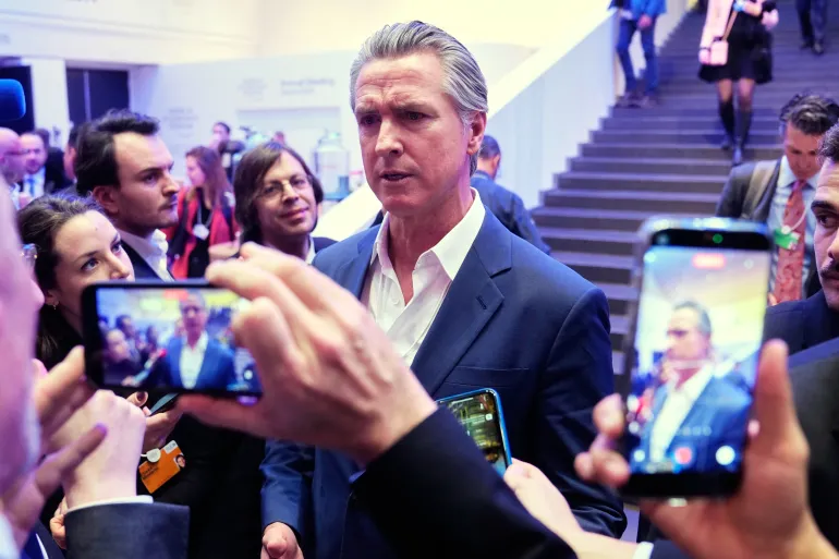 Gavin Newsom circondato dalle telecamere dei cellulari a Davos