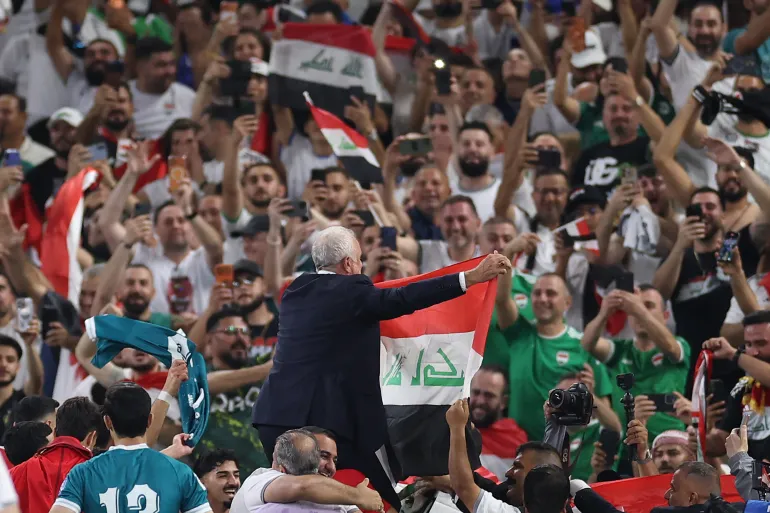 L'allenatore australiano iracheno Graham Arnold mostra la bandiera nazionale ai tifosi dopo aver vinto la partita di calcio finale delle qualificazioni alla Coppa del Mondo FIFA 2026 tra Iraq e Bolivia allo stadio BBVA di Guadalupe, stato di Nuevo Leon, Messico, il 31 marzo 2026. (Foto di Julio Cesar AGUILAR / AFP)
