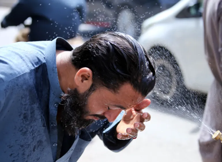 epa12934290 Un volontario spruzza acqua sulle persone come ristoro durante un'ondata di caldo a Karachi, Pakistan, 5 maggio 2026. Si prevede che Karachi rimarrà calda e secca nelle prossime 24 ore, con temperature inferiori a 40 gradi Celsius, ha detto il Dipartimento meteorologico pakistano, a seguito di un picco di 44,1 gradi Celsius, poiché si consiglia ai residenti di limitare l'esposizione e rimanere idratati. EPA/REHAN KHAN