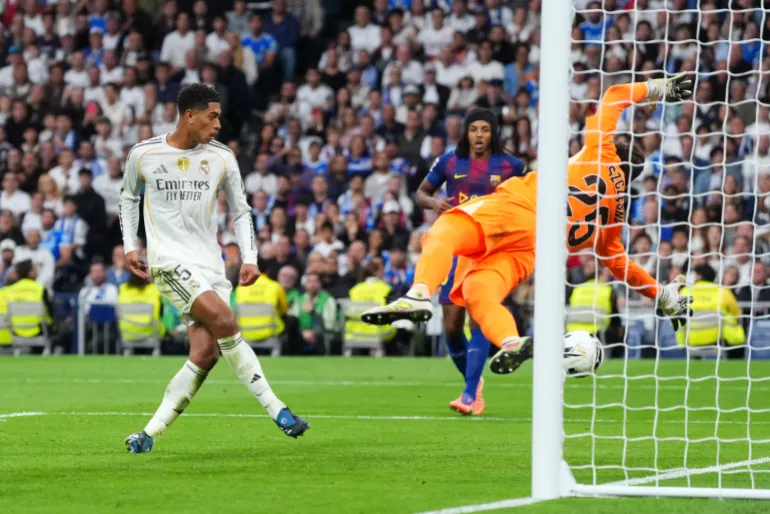MADRID, SPAGNA - 26 OTTOBRE: Jude Bellingham del Real Madrid segna il secondo gol della sua squadra mentre Wojciech Szczesny del FC Barcelona non riesce a salvare durante la partita LaLiga EA Sports tra il Real Madrid CF e il FC Barcelona all'Estadio Santiago Bernabeu il 26 ottobre 2025 a Madrid, Spagna. (Foto di Angel Martinez/Getty Images)