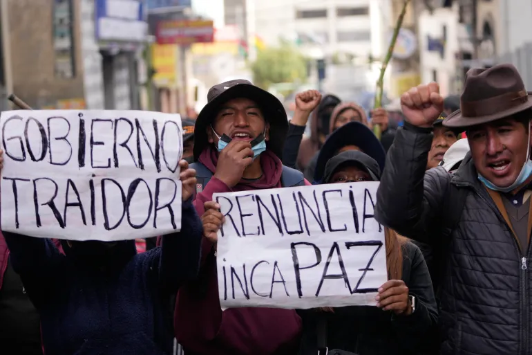 I manifestanti antigovernativi tengono cartelli con la scritta in spagnolo "Dimettiti Paz," E "Governo traditore" riferendosi al presidente Rodrigo Paz a La Paz, Bolivia, lunedì 18 maggio 2026