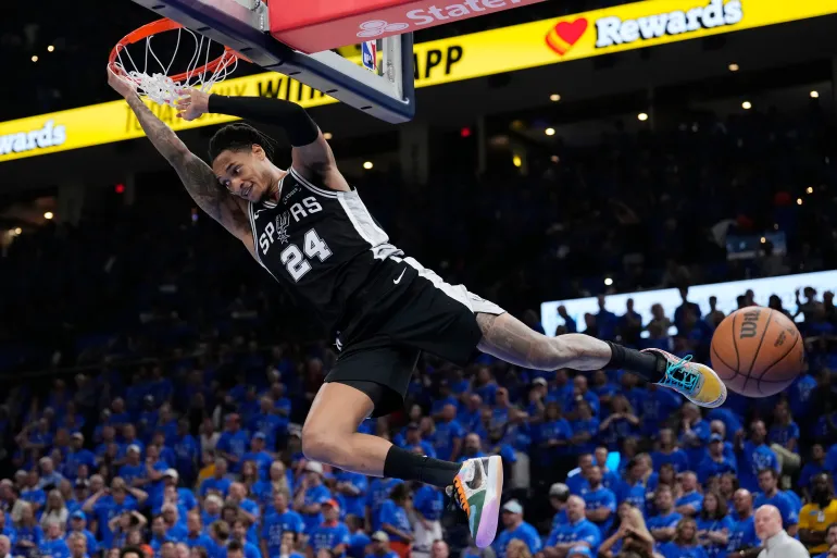 La guardia dei San Antonio Spurs Devin Vassell è appesa al bordo dopo una schiacciata contro gli Oklahoma City Thunder durante la seconda metà di Gara 7 delle finali della Western Conference della serie di playoff di basket NBA, sabato 30 maggio 2026, a Oklahoma City. (AP Photo/Tony Gutierrez)