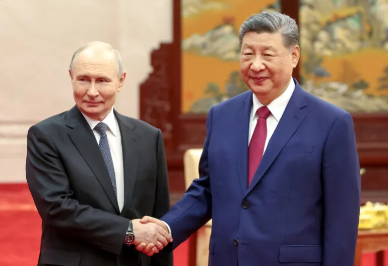 Il presidente russo Vladimir Putin e il presidente cinese Xi Jinping si stringono le mani mentre posano per le foto prima di una cerimonia del tè dopo il loro incontro nella Grande Sala del Popolo a Pechino, Cina, il 20 maggio 2026. Sputnik/Alexander Kazakov/Pool via REUTERS ATTENZIONE REDATTORI - QUESTA IMMAGINE È STATA FORNITA DA TERZE PARTI.