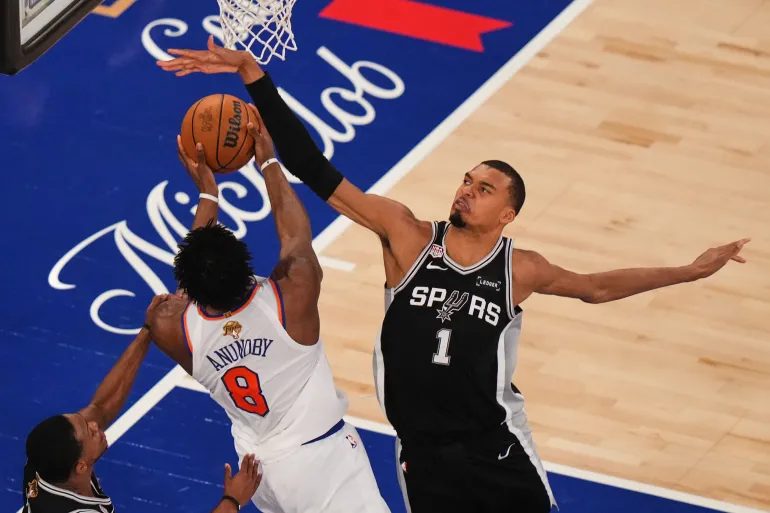 L'attaccante dei New York Knicks Og Anunoby (8) tenta di sparare sull'attaccante dei San Antonio Spurs Victor Wembanyama (1) durante la prima metà di Gara 4 della serie di basket delle finali NBA, mercoledì 10 giugno 2026, a New York. (AP Photo/Frank Franklin II)