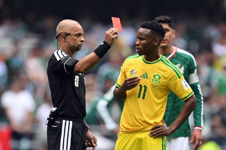 L'arbitro brasiliano Wilton Sampaio mostra un cartellino rosso al centrocampista sudafricano n. 11 Themba Zwane durante la partita di calcio del Gruppo A della Coppa del Mondo 2026 tra Messico e Sud Africa