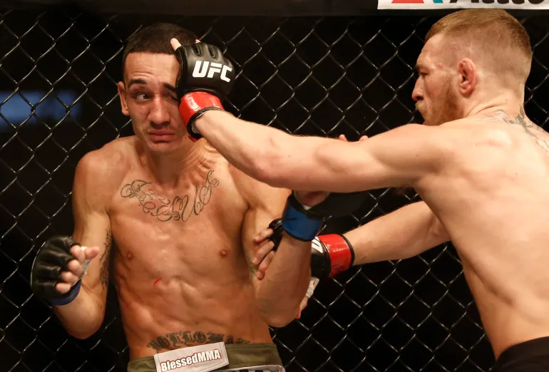 17 agosto 2013; Boston, Massachusetts, Stati Uniti; Conor McGregor (pantaloncini neri) e Max Holloway (pantaloncini bianchi) combattono durante una partita dei pesi piuma UFC al TD Garden. McGregor ha vinto dopo tre round per decisione dei giudici. Credito obbligatorio: Winslow Townson-USA TODAY Sports