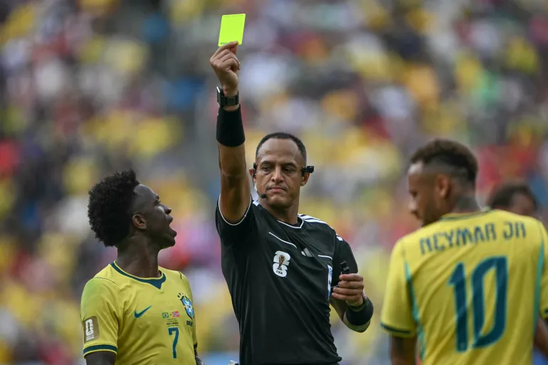 L'arbitro statunitense Ismail Elfath mostra un cartellino giallo all'attaccante n. 10 del Brasile Neymar (fuori dall'inquadratura) durante gli ottavi di finale della Coppa del Mondo 2026 tra Brasile e Norvegia allo stadio New York/New Jersey di East Rutherford il 5 luglio 2026. (Foto di MAURO PIMENTEL / AFP)