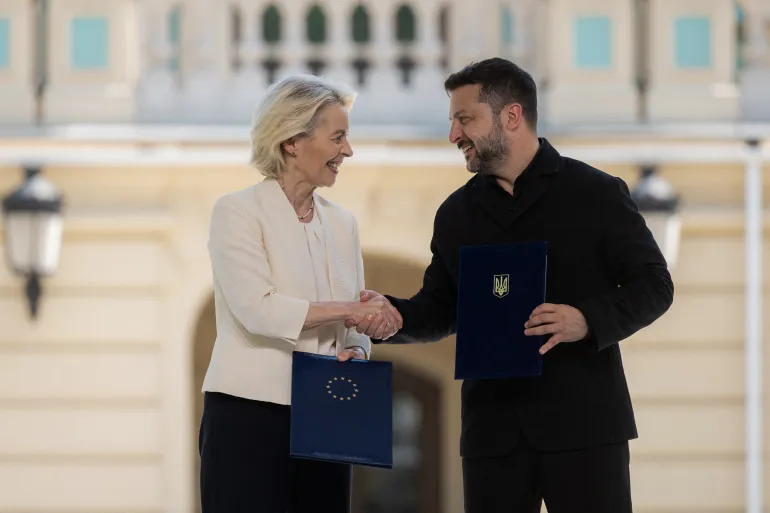 Questa fotografia scattata e pubblicata dal Servizio stampa presidenziale ucraino il 15 luglio 2026 mostra il presidente ucraino Volodymyr Zelensky e il presidente della Commissione europea Ursula von der Leyen che si stringono la mano mentre tengono in mano documenti bilaterali firmati dopo il loro incontro a Kiev, nel mezzo dell'invasione russa dell'Ucraina. (Photo by Handout / SERVIZIO STAMPA PRESIDENZIALE UCRAINO / AFP) / LIMITATO ALL'USO EDITORIALE - CREDITO OBBLIGATORIO "FOTO AFP / Servizio stampa presidenziale ucraino" - NESSUN MARKETING NESSUNA CAMPAGNA PUBBLICITARIA - DISTRIBUITO COME SERVIZIO AI CLIENTI