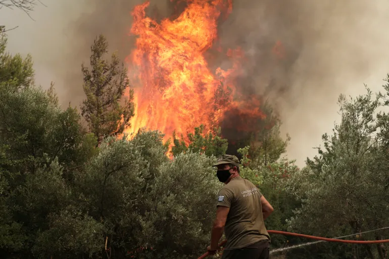 Un pompiere cerca di spegnere un incendio nel villaggio di Avgaria, sull'isola di Evia, Grecia, il 10 agosto 2021. REUTERS/Stelios Misinas