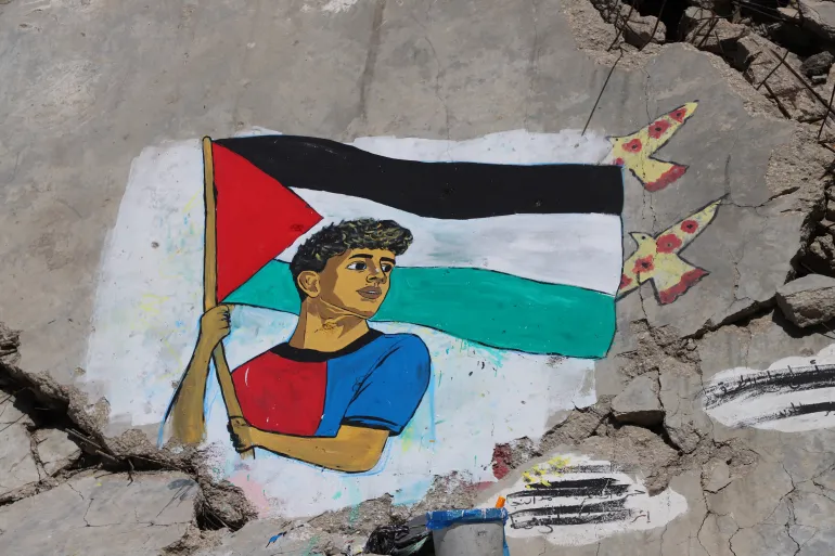 Un murale dipinto da artisti palestinesi raffigura la stella del calcio Lamine Yamal, che sventolò una bandiera palestinese durante la parata della vittoria LaLiga di Barcellona, sulle macerie degli edifici distrutti durante la guerra, nel campo profughi di Shati (spiaggia) a Gaza City, il 13 maggio 2026. REUTERS/Ebrahim Hajjaj