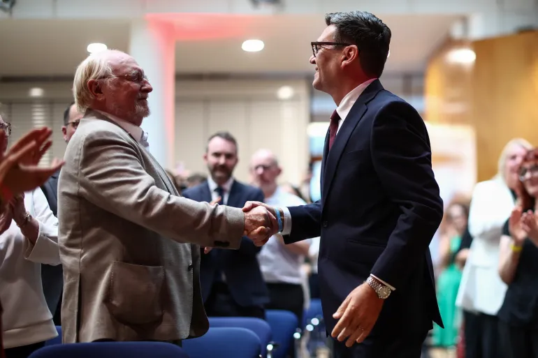 epa13117115 Andy Burnham (R) stringe la mano a Neil Kinnock (L), ex leader del partito laburista negli anni '80 e '90, quando arriva prima di essere confermato come nuovo leader del partito laburista e prossimo primo ministro del paese durante la 