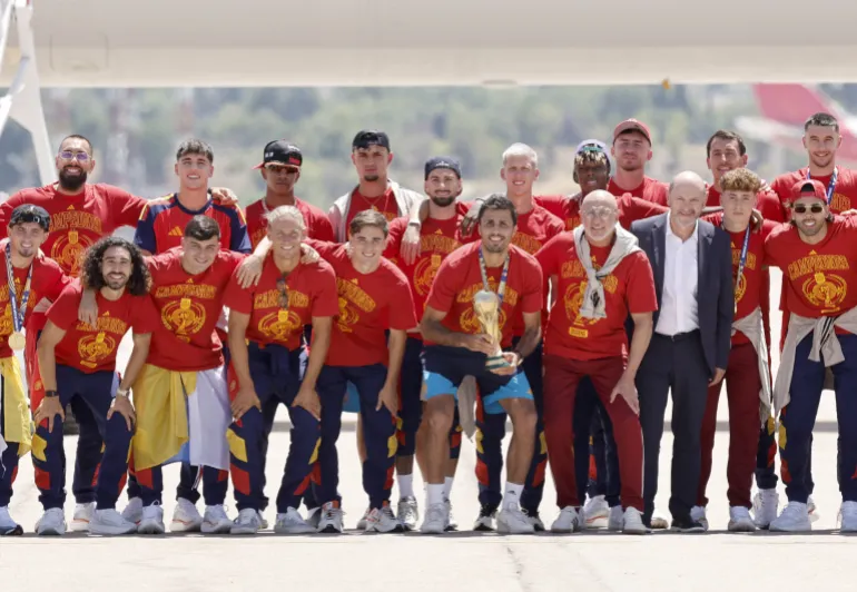 La squadra spagnola posa con il trofeo sull'asfalto al suo arrivo dagli Stati Uniti dopo aver vinto la Coppa del Mondo 2026, all'aeroporto di Madrid Barajas, il 20 luglio 2026. I vincitori della Coppa del Mondo spagnola tornano a casa accolti da eroi a Madrid, dove si prevede che un milione di tifosi li accoglieranno dopo una notte di chiassosi festeggiamenti in tutto il paese. (Foto di Oscar DEL POZO/AFP)
