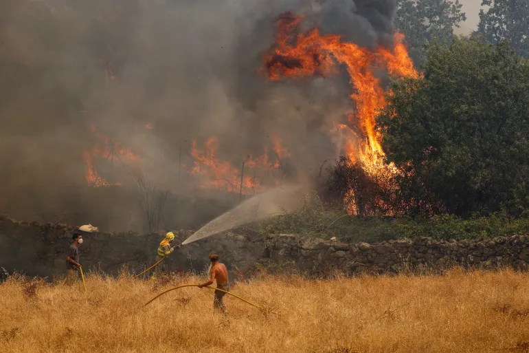 Vigili del fuoco e civili tentano di spegnere un incendio che si avvicina alle case il 24 luglio 2026 a El Tiemblo, nella provincia di Ávila, in Spagna. Il ministro degli Interni spagnolo ha dichiarato lo stato di emergenza poiché più di 11.500 persone sono state costrette a evacuare le proprie case a causa degli incendi in tutto il paese. (Foto di Pablo Blazquez Dominguez/Getty)