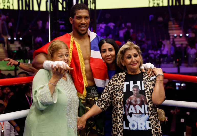 Boxe - il ritorno - Anthony Joshua v Kristian Prenga - Jeddah Superdome, Jeddah, Arabia Saudita - 26 luglio 2026 Anthony Joshua posa per una foto con la famiglia dei suoi amici, Latz e Sina, morto in un tragico incidente automobilistico, dopo aver vinto la sua lotta contro Kristian Prenga con un knockout tecnico REUTERS/Ibraheem Abu Mustafa