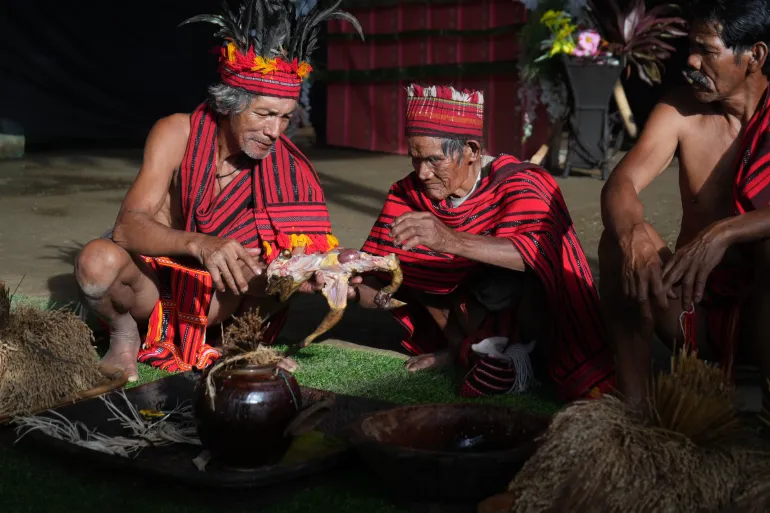 Apu Buy-a Nadyug [centre]il capo sacerdote indigeno di Batad, si unisce ad altri due anziani del villaggio durante il Tanig, un rituale di benedizione prima dell'inizio della festa del raccolto.