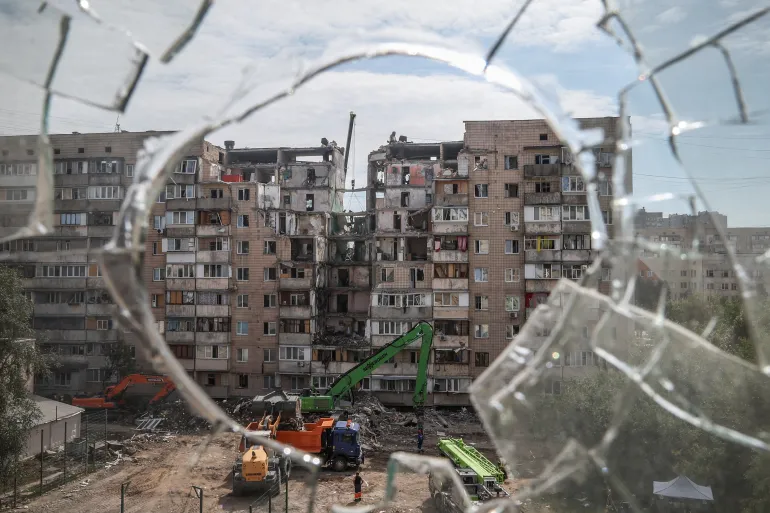 I soccorritori che lavorano sul luogo di un attacco missilistico e di droni russi il giorno precedente, durante il quale l'edificio residenziale è stato gravemente danneggiato, durante l'attacco della Russia all'Ucraina, sono visti attraverso vetri rotti, a Kiev, Ucraina, il 7 luglio 2026. REUTERS/Alina Smutko IMMAGINI TPX DEL GIORNO