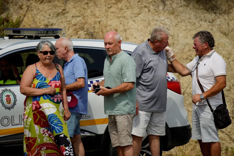 I residenti colpiti da incendi mortali attendono l'accesso della polizia per tornare alle loro case a Bedar, Almeria, Spagna, 12 luglio 2026. REUTERS/Ana Beltran