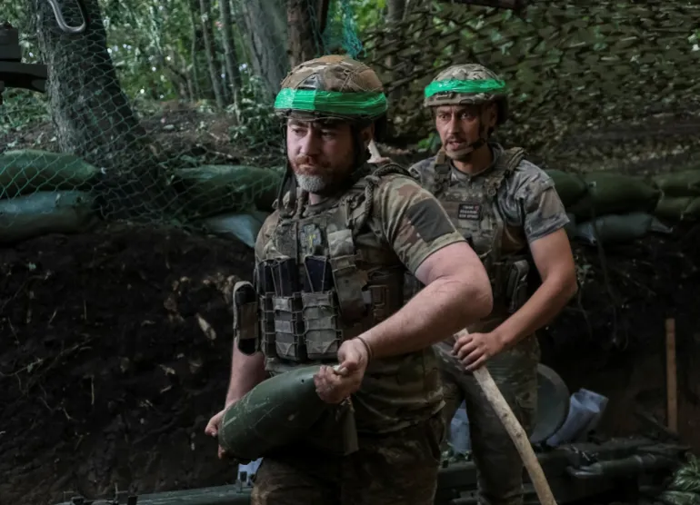 Un militare della 15a Brigata 'Kara-Dag' dell'incarico operativo della Guardia Nazionale dell'Ucraina porta una conchiglia mentre si prepara a sparare un obice 2A65 Msta-B da 152 mm verso le truppe russe, nel mezzo dell'attacco russo all'Ucraina, in una posizione vicino alla città di prima linea di Dobropillia, nella regione di Donetsk, Ucraina, 8 luglio 2026. REUTERS/Anatolii Stepanov