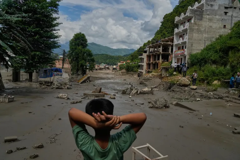Un ragazzo guarda la devastazione causata dalle inondazioni improvvise lungo il fiume Trishuli nel distretto di Nuwakot in Nepal, mercoledì 26 agosto 2026. (AP Photo/Niranjan Shrestha)