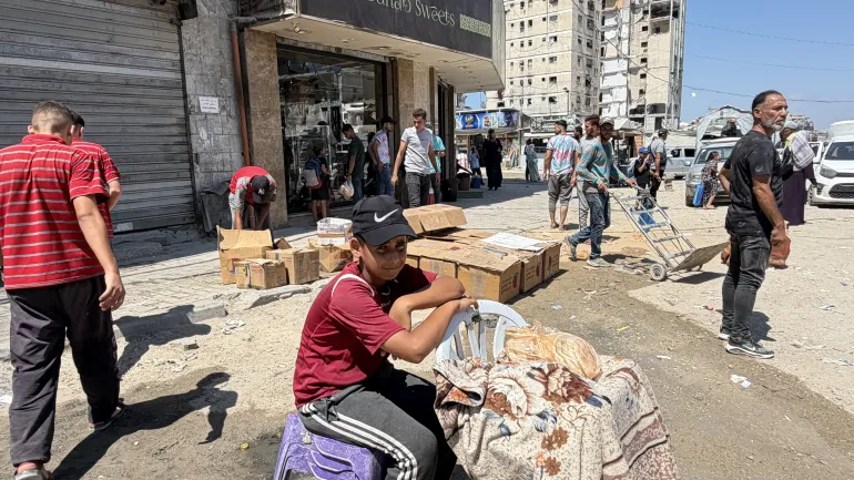 Abdel Hadi Abu Shaaban, al centro, utilizza Internet da un negozio vicino per ricevere pagamenti bancari online
