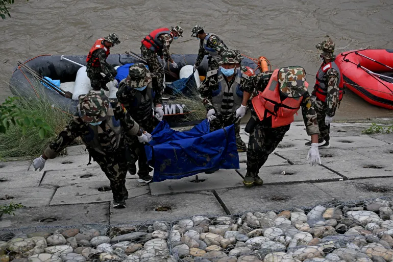 Il personale dell'esercito nepalese trasporta i corpi delle vittime delle inondazioni durante un'operazione di ricerca lungo il fiume Narayani a Bharatpur, nel distretto nepalese di Chitwan, il 31 agosto 2026. Il Nepal stava seppellendo il 31 agosto alcune delle centinaia di corpi recuperati dopo che un'alluvione mortale simile a uno tsunami si è abbattuta sulla regione dell'Himalaya, spazzando via villaggi e lasciando migliaia di persone ancora dispersi. (Foto di PRAKASH MATHEMA / AFP)