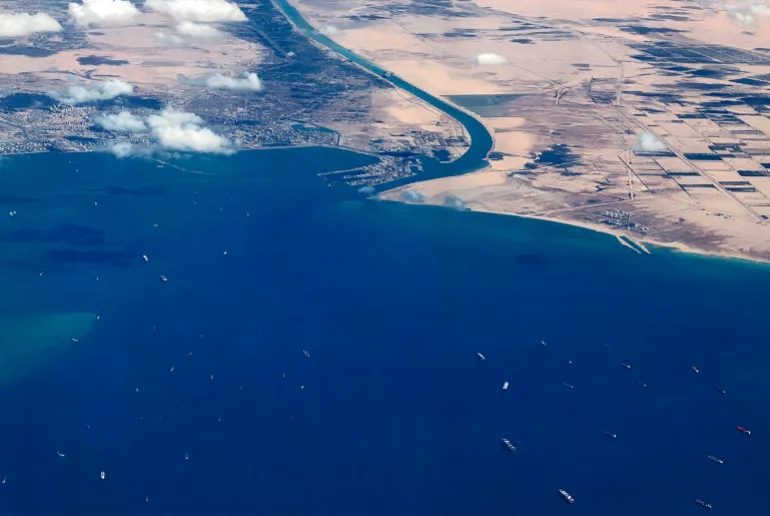 Una veduta aerea scattata il 27 marzo 2021 dall'oblò di un aereo commerciale mostra navi arenate in coda nel Golfo di Suez per attraversare il Canale di Suez al suo ingresso meridionale vicino alla città portuale di Suez sul Mar Rosso.