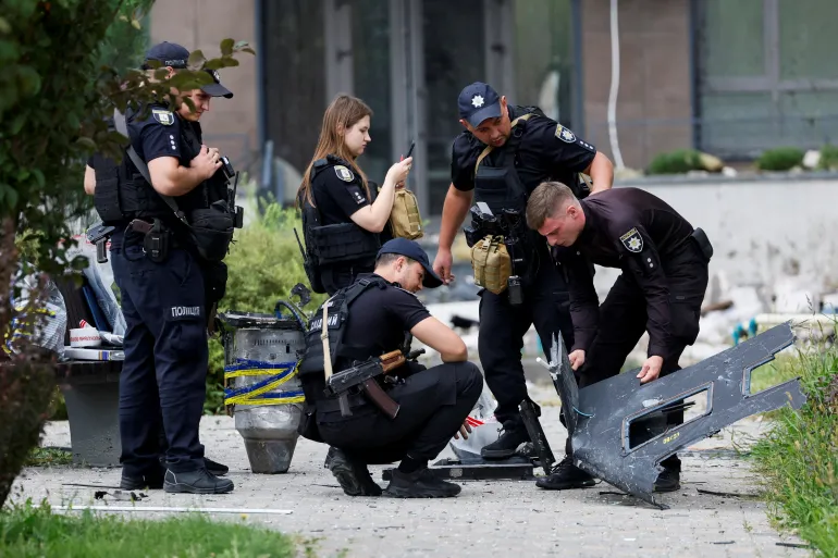 Gli agenti di polizia ispezionano parti di un drone russo, nel sito di un condominio danneggiato da un attacco di droni russi, nel mezzo dell'attacco della Russia all'Ucraina, a Kiev, Ucraina, 1 settembre 2026. REUTERS/Gleb Garanich IMMAGINI TPX DEL GIORNO