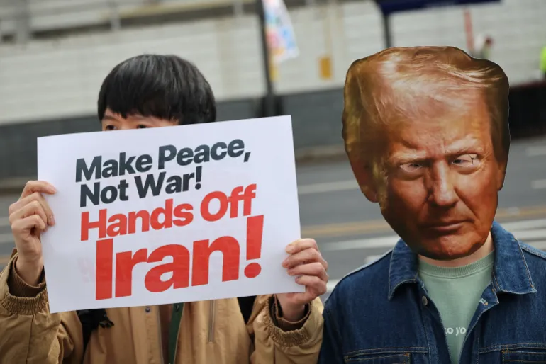 Un attivista che indossa una maschera ritagliata di Trump partecipa a una manifestazione per condannare la guerra USA-Israele all'Iran, con altri davanti all'ambasciata americana a Seul, Corea del Sud, 1 marzo 2026