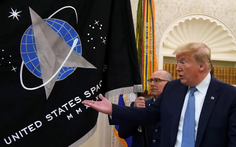 Il presidente degli Stati Uniti Donald Trump fa un gesto verso la bandiera della US Space Force durante una presentazione della bandiera nello Studio Ovale della Casa Bianca a Washington, DC, Stati Uniti, 15 maggio 2020