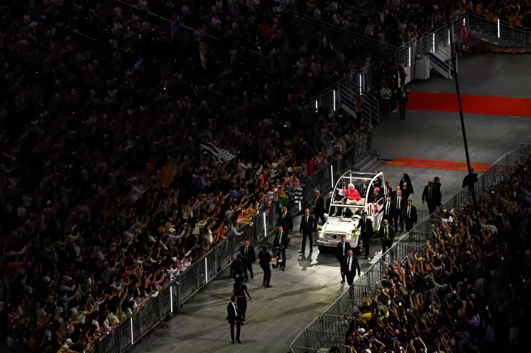 TOPSHOT - Papa Leone XIV saluta i fedeli dalla Papamobile (papamobile) allo stadio Stade de France, a Saint-Denis, alla periferia di Parigi, il 25 settembre 2026 quando arriva per condurre una veglia di preghiera con i giovani, come parte della sua visita di quattro giorni in Francia.