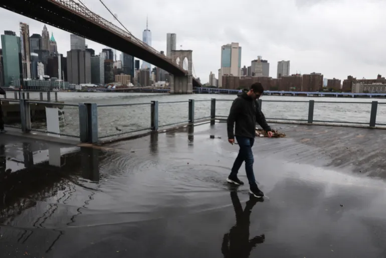 NEW YORK CITY - 26 SETTEMBRE: Grandi pozzanghere e detriti fiancheggiano una passerella nel quartiere di Dumbo a Brooklyn mentre una tempesta Nor'easter si muove attraverso l'area il 26 settembre 2026 a New York City. New York e gran parte del nord-est si aspettano un fine settimana di forti venti, pioggia e possibili inondazioni nelle comunità costiere durante il passaggio della tempesta. Spencer Platt/Getty Images/AFP (Foto di SPENCER PLATT / GETTY IMAGES NORD AMERICA / Getty Images via AFP)