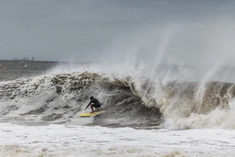 Un surfista prende un'onda mentre un nor'easter batte la costa nord-orientale degli Stati Uniti, a Rockaway, New Jersey, Stati Uniti, 26 settembre 2026. REUTERS/Caitlin Ochs