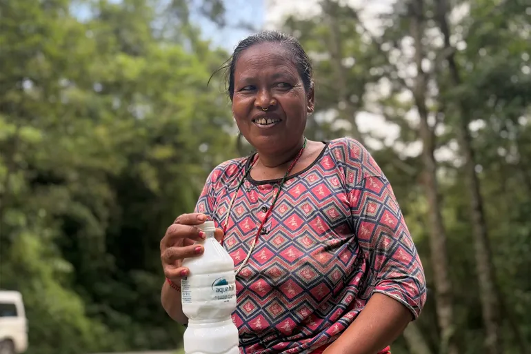 Con in mano una bottiglia di latticello, Seeta Nepali aspetta l'arrivo dei turisti