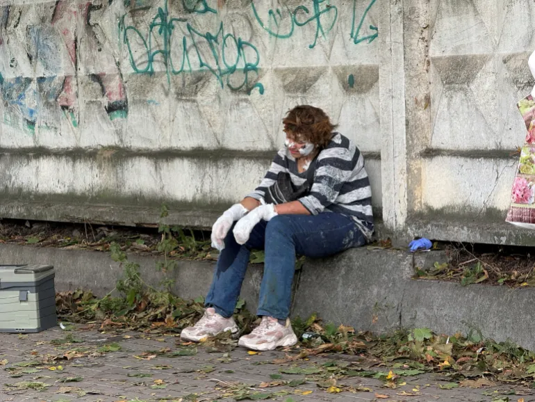 Una donna ferita siede vicino a un centro commerciale colpito da un attacco di droni russi, nel mezzo dell'attacco russo all'Ucraina a Kiev, Ucraina, il 23 settembre 2026. Foto scattata con un telefono cellulare. REUTERS/Stringer IMMAGINI TPX DEL GIORNO