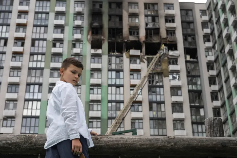 Un ragazzo si trova vicino al sito di un edificio residenziale gravemente danneggiato a seguito di uno sciopero russo a Kiev il 1° settembre 2026, durante l’invasione russa dell’Ucraina.