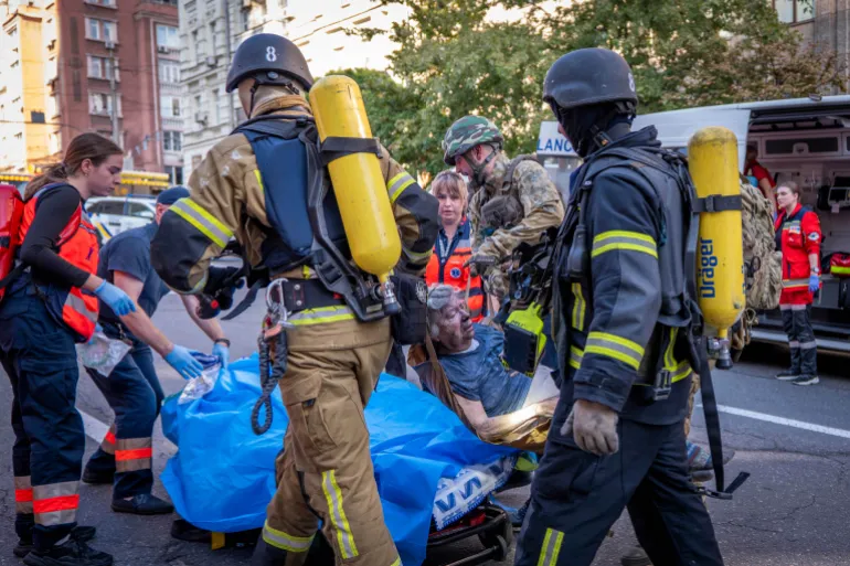 I soccorritori evacuano una donna ferita da un ospedale danneggiato dopo un attacco di droni russi nel centro di Kiev, in Ucraina, a settembre