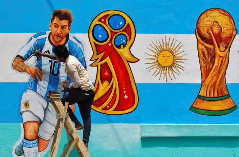 Un pittore applica gli ultimi ritocchi a un'immagine del calciatore argentino Lionel messi, su un muro lungo una strada davanti alla Coppa del mondo FIFA, a Calcutta, India, 8 giugno 2018. REUTERS/Rupak De Chowdhuri