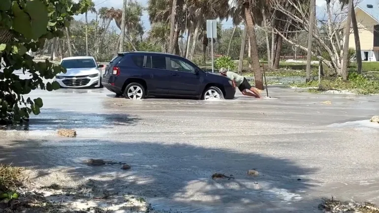 Un uomo cerca di spingere un'auto mentre le onde si infrangono sulla strada prima dell'arrivo dell'uragano Isaias, a Englewood, Florida, Stati Uniti, 9 ottobre 2026. Distretto di controllo antincendio dell'area di Englewood tramite Facebook/Handout tramite REUTERS QUESTA IMMAGINE È STATA FORNITA DA TERZE PARTI. NESSUNA RIVENDITA. NESSUN ARCHIVIO. CREDITO OBBLIGATORIO. Linee di verifica: edifici, pali elettrici, segnali stradali, tracciato stradale e alberi hanno abbinato file e immagini satellitari nell'area. Data verificata dai rapporti governativi di Manasota Key Road a Englewood, in Florida, è stata chiusa a causa delle onde che si riversavano sulla strada. Il National Hurricane Center degli Stati Uniti ha dichiarato che l'uragano Isaias si è abbattuto sulla penisola occidentale della Florida, avvertendo del pericolo di mareggiate e inondazioni.