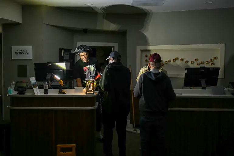 Gli ospiti dell'hotel vengono assistiti nell'uso delle torce elettriche poiché l'elettricità si è interrotta poco prima dell'atterraggio dell'uragano Isaias a Pensacola, in Florida, il 9 ottobre 2026. [AFP]