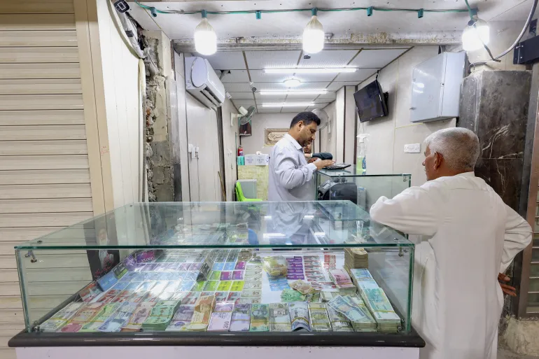 Un cliente si trova in un negozio di cambio valuta a Najaf, Iraq, 7 ottobre 2026 [Alaa Al-Marjani/ Reuters]