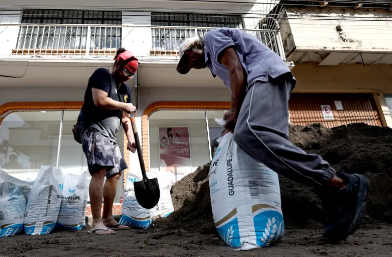Un uomo riempie un sacco di sabbia per costruire una barricata per proteggere la sua attività dal potenziale impatto dell'uragano Simon a Puerto Vallarta, nello stato di Jalisco, in Messico, il 9 ottobre 2026. Si prevede che l'uragano Simon si rafforzerà rapidamente prima di colpire la costa pacifica del Messico, ha dichiarato il National Hurricane Center degli Stati Uniti il 9 ottobre. (Foto di ULISES RUIZ / AFP)