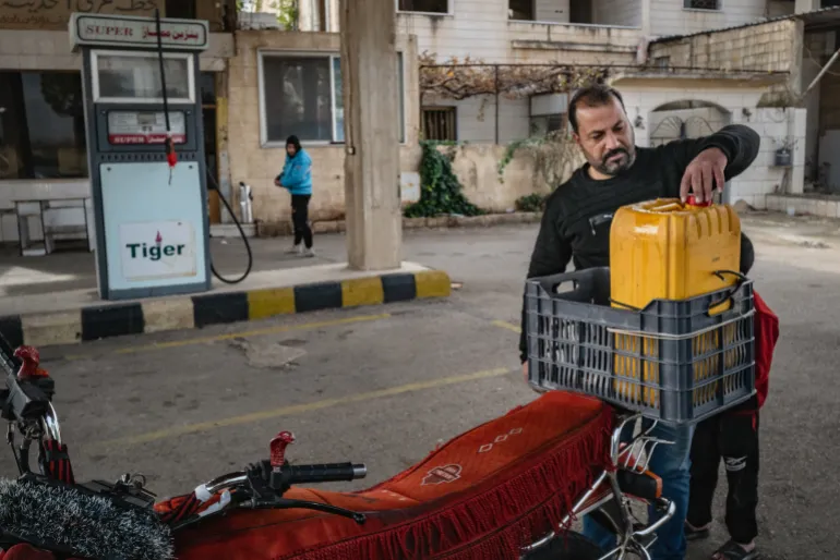 Un uomo riempie un contenitore di petrolio per il riscaldamento di una casa a Suwayda, in Siria