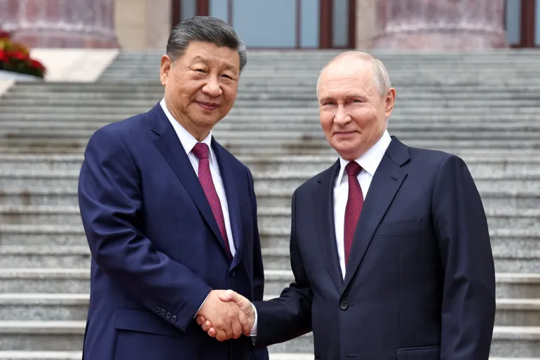 Il presidente russo Vladimir Putin stringe le mani con il presidente cinese Xi Jinping durante una cerimonia di benvenuto presso la Grande Sala del Popolo a Pechino, Cina, 20 maggio 2026. Sputnik/Alexander Kazakov/Pool via REUTERS ATTENZIONE REDATTORI - QUESTA IMMAGINE È STATA FORNITA DA TERZE PARTI. IMMAGINI TPX DEL GIORNO