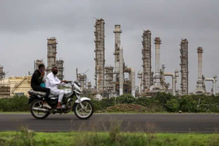 Un motociclista passa davanti alla raffineria di petrolio della Reliance Industries Ltd. a Jamnagar, Gujarat, India