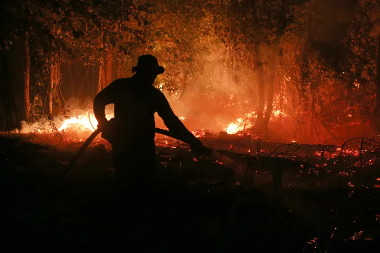 Un vigile del fuoco spruzza acqua nel tentativo di spegnere un incendio che ha devastato una foresta di torbiere a Pulang Pisau, Kalimantan centrale, Indonesia, il 5 settembre 2026