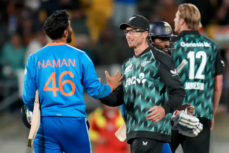 Naman Dhir (a sinistra) dell'India si congratula con il capitano della Nuova Zelanda Mitchell Santner dopo la vittoria durante la terza partita di cricket T20i tra Nuova Zelanda e India allo stadio Hnry di Wellington il 27 ottobre 2026. (Foto di Marty MELVILLE / AFP)
